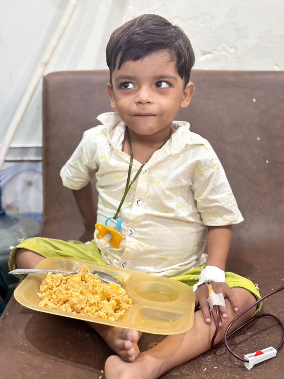 A young patient eating a free meal during his transfusion at KTCC